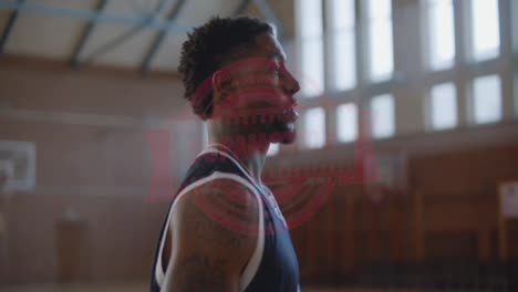 Handsome-African-American-black-basketball-player-in-generic-uniform-looking-and-talking-into-camera,-basketball-arena-in-the-background.-4K-UHD